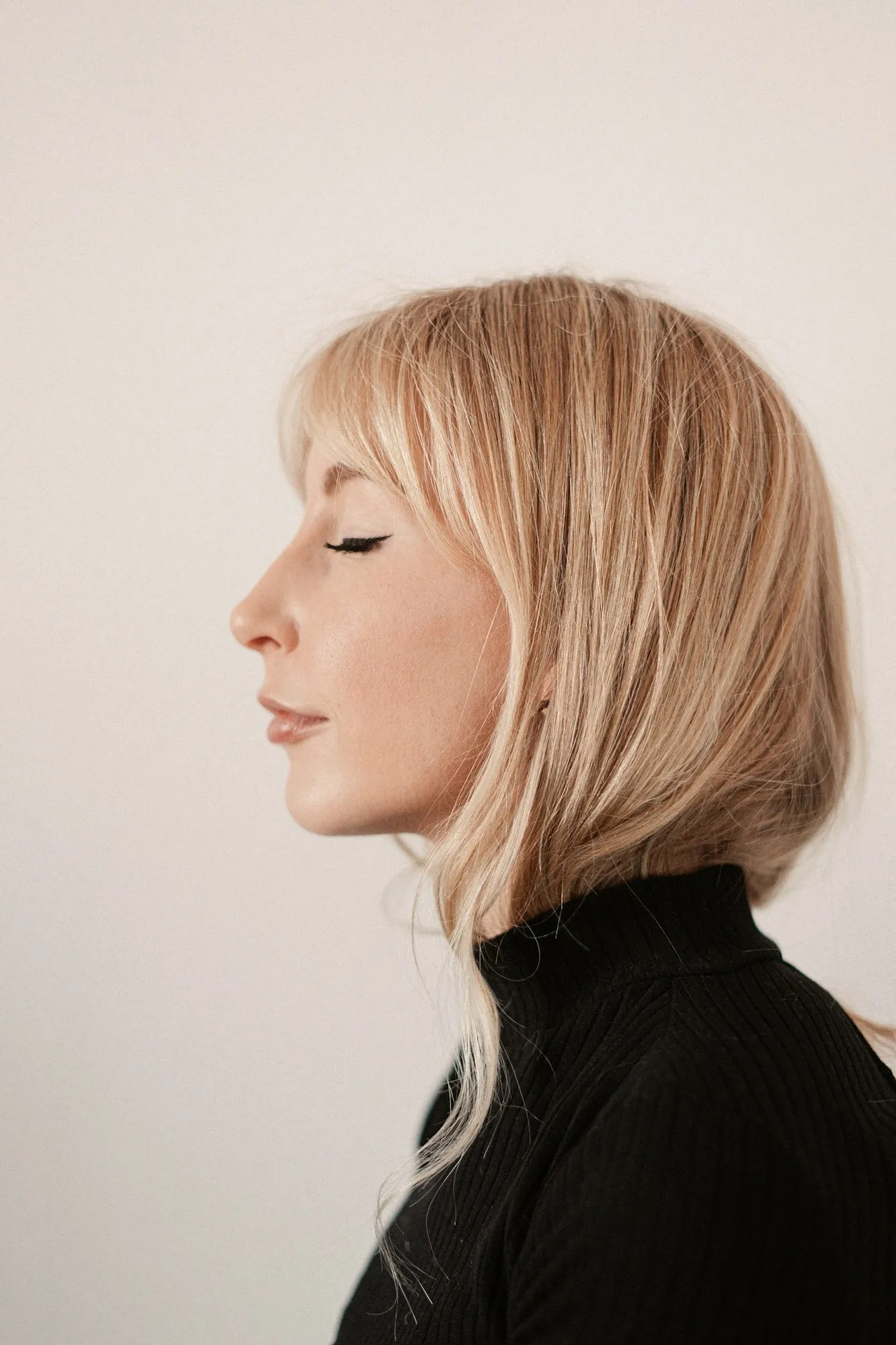 Woman with a light bob and fringe, in profile